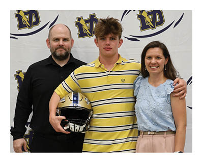 A man and woman pose with a football player in front of a football banner. AI generated content