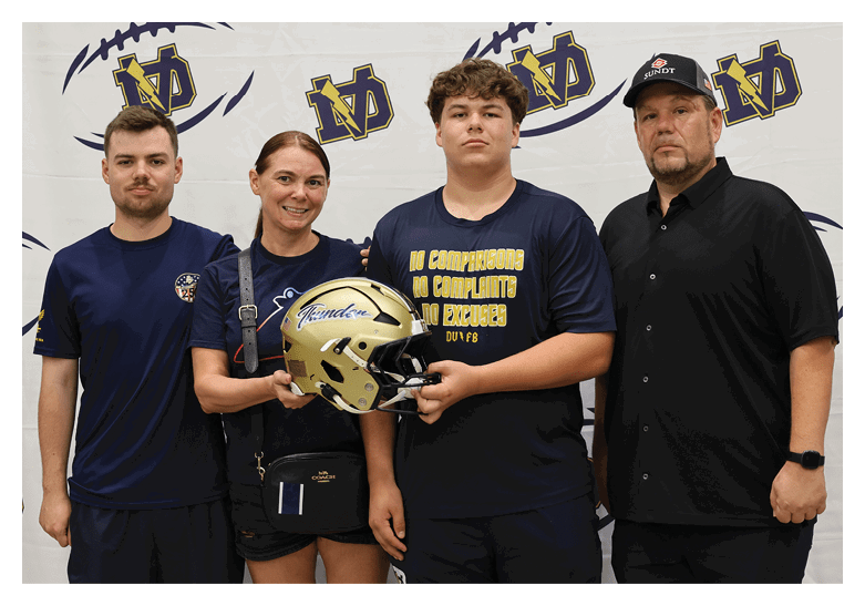 Four people pose with a football helmet. AI generated content