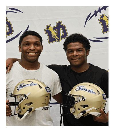 Two young men are holding football helmets. AI generated content