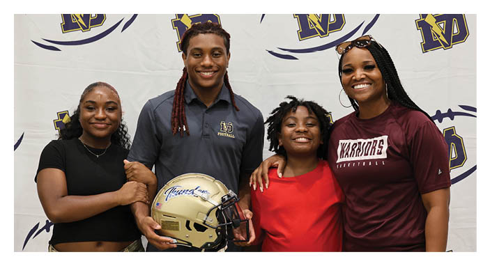 A group of people, including a man holding a football helmet, pose for a picture. AI generated content
