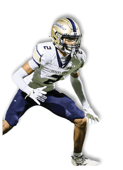 A person wearing a football uniform with a helmet and gloves is in a crouched, ready stance on the field. Description generated by AI