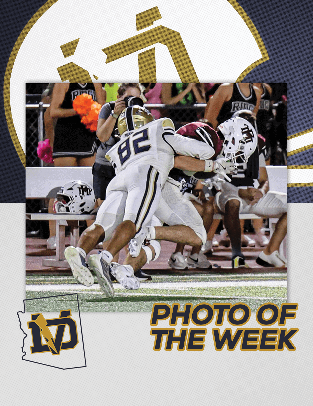 Two football players in action on the field with one tackling the other while people sit on a bench in the background and the text “Photo of the Week" appears below. Description generated by AI