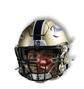 A person wearing a gold football helmet with a black faceguard and a red mouthguard is looking forward against a dark background. Description generated by AI