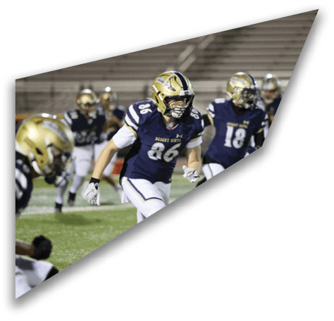 People wearing football uniforms and helmets are actively running on a field during a game or practice. Description generated by AI