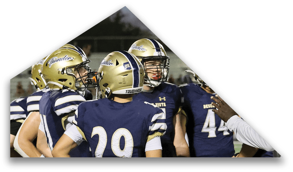 A group of people wearing navy blue and gold football uniforms and helmets are gathered closely together on a field. Description generated by AI