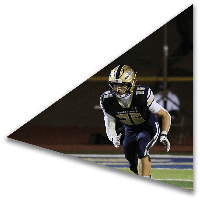 A person wearing white shoes and pink socks is running on a green football field with white yard lines. Description generated by AI