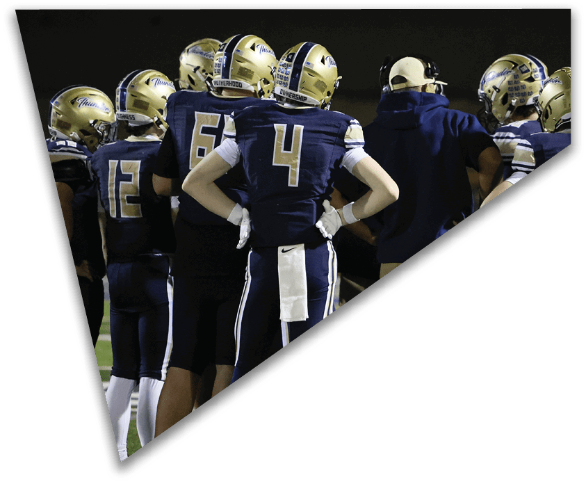 Several people wearing athletic pants and shoes stand on a sports field with green turf and white lines. Description generated by AI