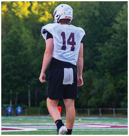 A football player wearing a blue and red jersey. Description generated by AI