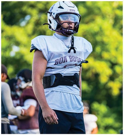 A football player wearing a blue and red jersey. Description generated by AI
