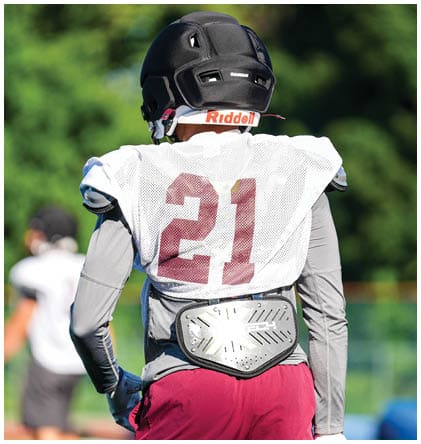 A football player wearing a blue and red jersey. Description generated by AI