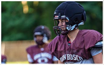 A football player wearing a blue and red jersey. Description generated by AI