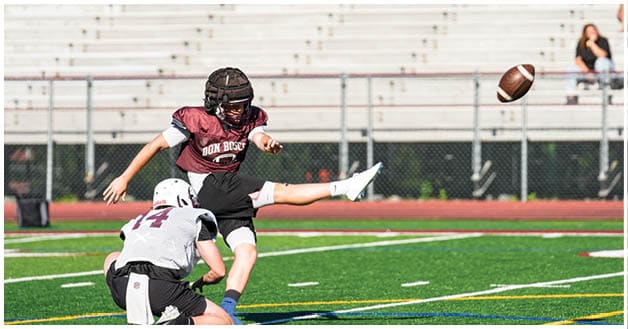 A football player wearing a blue and red jersey. Description generated by AI