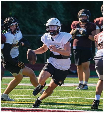 A football player wearing a blue and red jersey. Description generated by AI