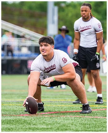 A football player wearing a blue and red jersey. Description generated by AI