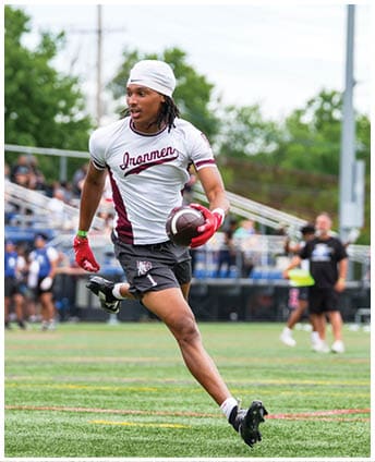 A football player wearing a blue and red jersey. Description generated by AI