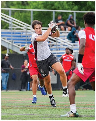 A football player wearing a blue and red jersey. Description generated by AI