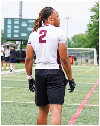 A football player wearing a blue and red jersey. Description generated by AI