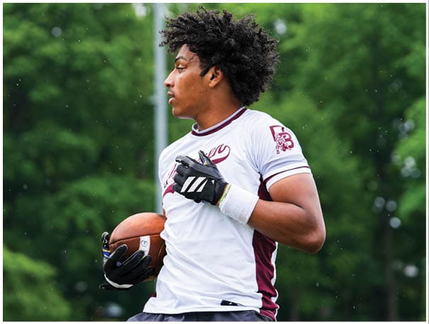 A football player wearing a blue and red jersey. Description generated by AI
