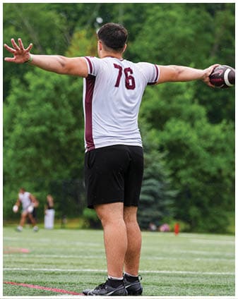 A football player wearing a blue and red jersey. Description generated by AI