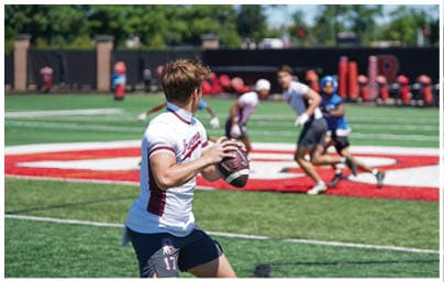 A football player wearing a blue and red jersey. Description generated by AI