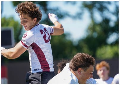A football player wearing a blue and red jersey. Description generated by AI