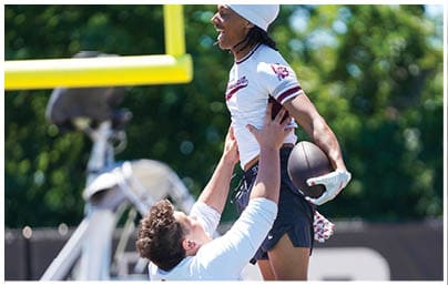 A football player wearing a blue and red jersey. Description generated by AI