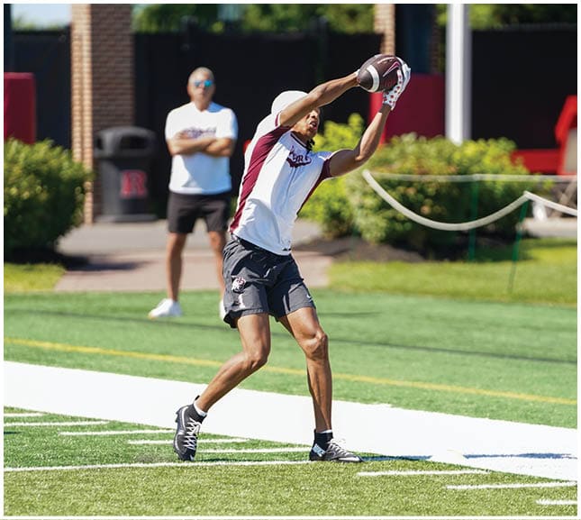 A football player wearing a blue and red jersey. Description generated by AI