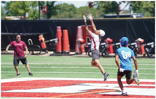A football player wearing a blue and red jersey. Description generated by AI