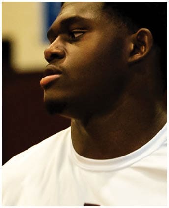 A football player wearing a blue and red jersey. Description generated by AI
