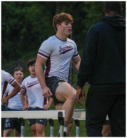 A football player wearing a blue and red jersey. Description generated by AI