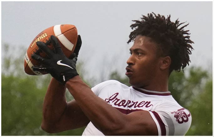 A football player wearing a blue and red jersey. Description generated by AI
