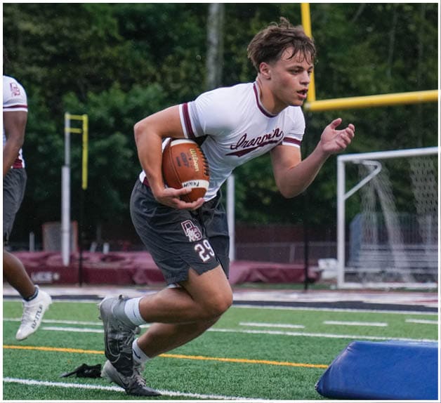 A football player wearing a blue and red jersey. Description generated by AI