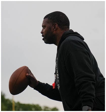 A football player wearing a blue and red jersey. Description generated by AI