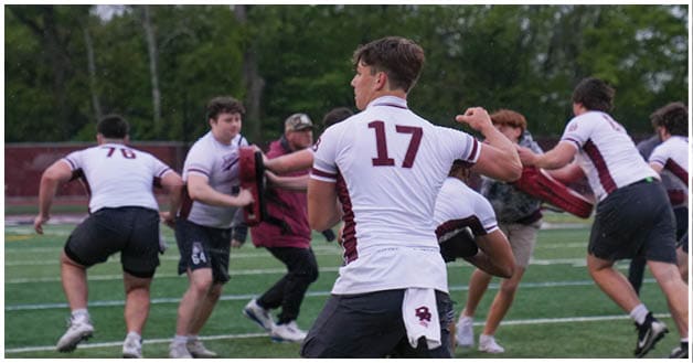 A football player wearing a blue and red jersey. Description generated by AI
