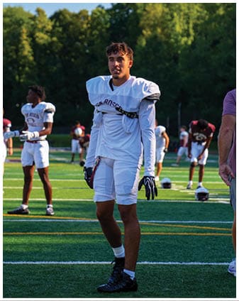 A football player wearing a blue and red jersey. Description generated by AI