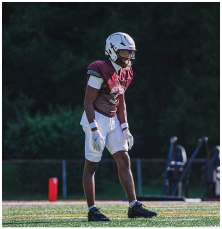 A football player wearing a blue and red jersey. Description generated by AI