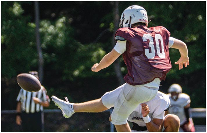 A football player wearing a blue and red jersey. Description generated by AI