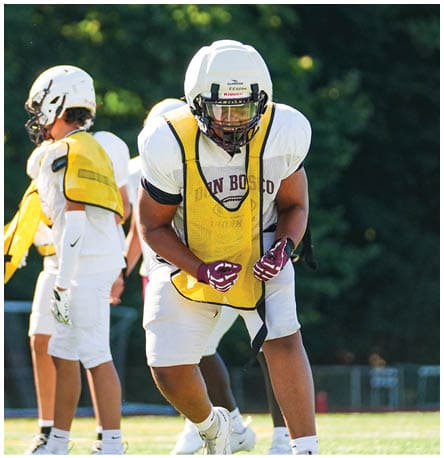 A football player wearing a blue and red jersey. Description generated by AI