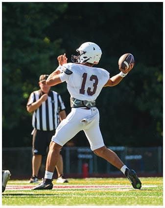 A football player wearing a blue and red jersey. Description generated by AI