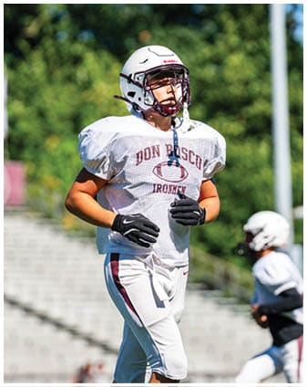 A football player wearing a blue and red jersey. Description generated by AI