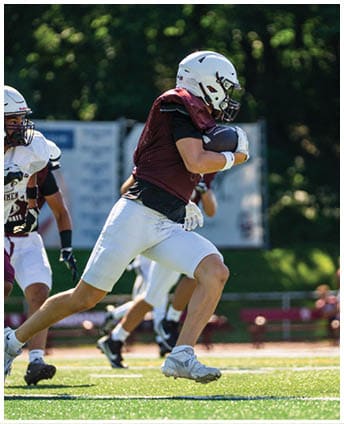 A football player wearing a blue and red jersey. Description generated by AI