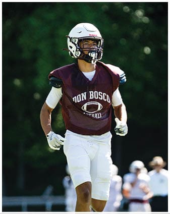 A football player wearing a blue and red jersey. Description generated by AI