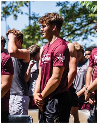 A football player wearing a blue and red jersey. Description generated by AI