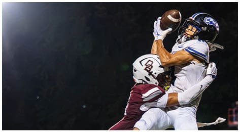 A football player wearing a blue and red jersey. Description generated by AI