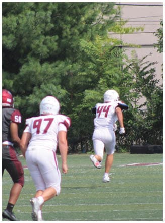 A football player wearing a blue and red jersey. Description generated by AI