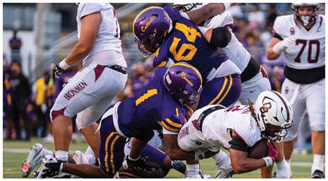 A football player wearing a blue and red jersey. Description generated by AI