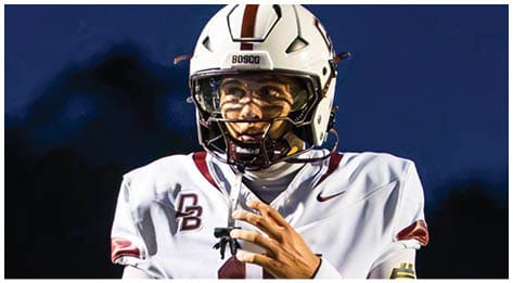 A football player wearing a blue and red jersey. Description generated by AI