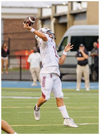 A football player wearing a blue and red jersey. Description generated by AI