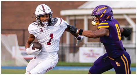 A football player wearing a blue and red jersey. Description generated by AI