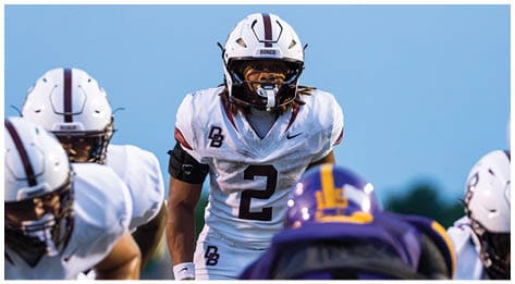A football player wearing a blue and red jersey. Description generated by AI